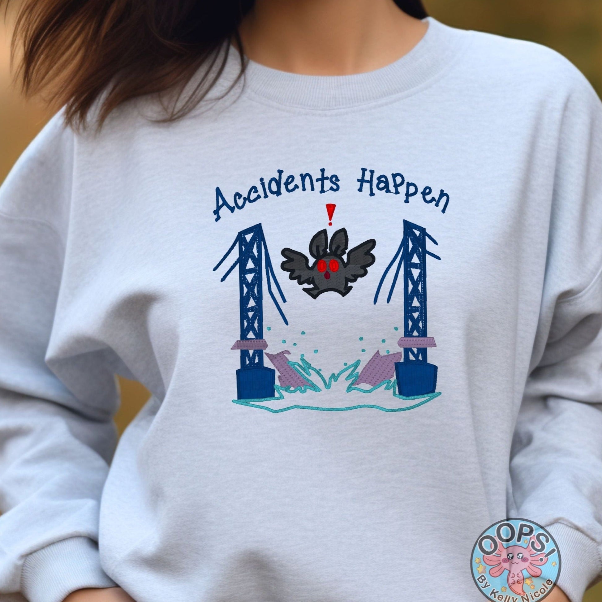 Mothman "Accidents Happen" Funny Embroidered Heavyweight Unisex Sweatshirt in ASH  Shop online today to get yours at HTTPS://OOPSBYKELLYNICOLE.COM 