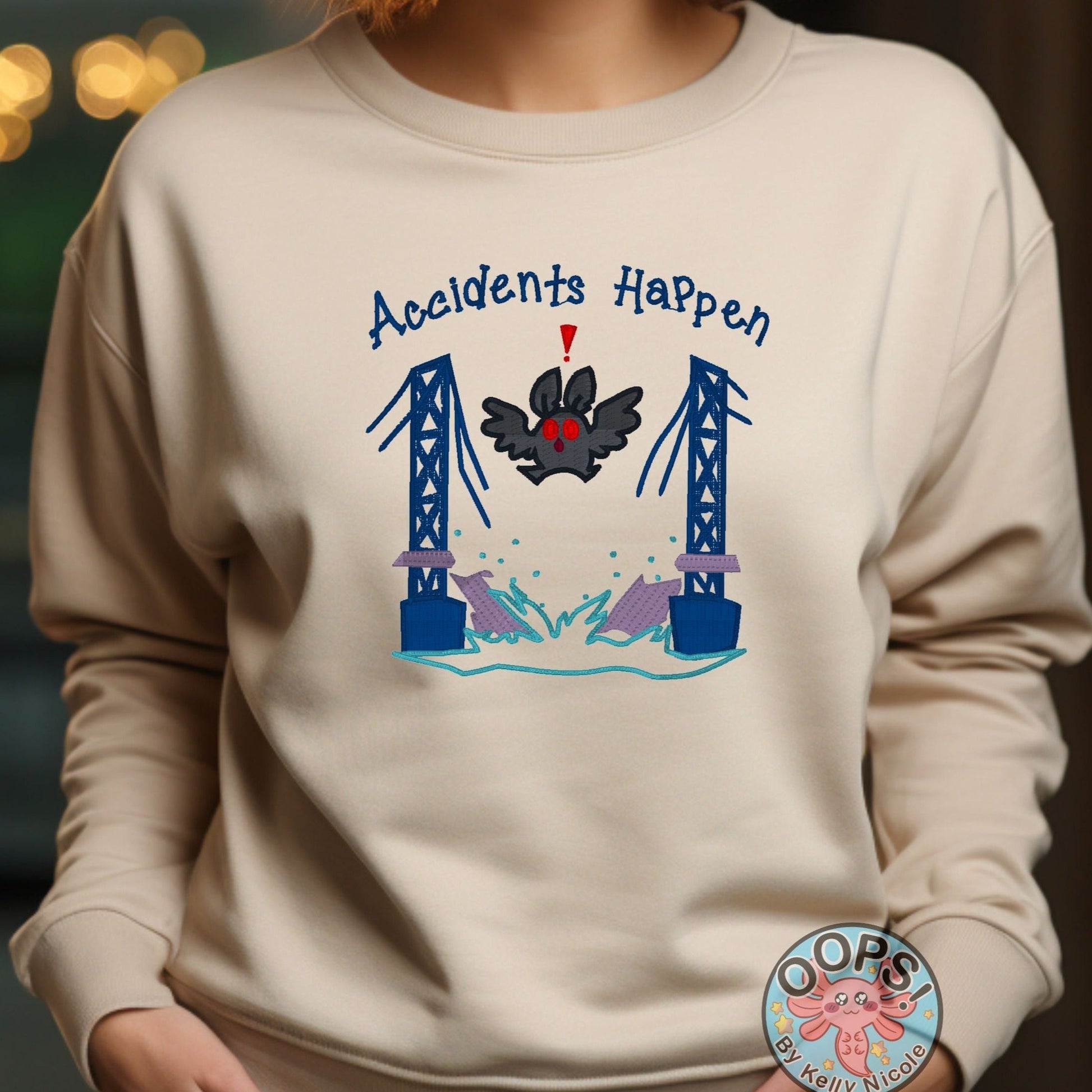 Mothman "Accidents Happen" Funny Embroidered Heavyweight Unisex Sweatshirt in SAND  Shop online today to get yours at HTTPS://OOPSBYKELLYNICOLE.COM 