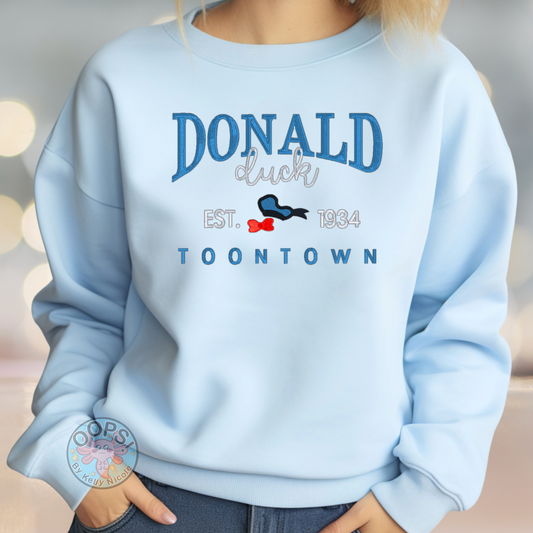 Embroidered Donald Duck Unisex Blue Sweatshirt, perfect for Home, work or anytime cozy comfort wear. Order yours today at “https://oopsbykellynicole.com”