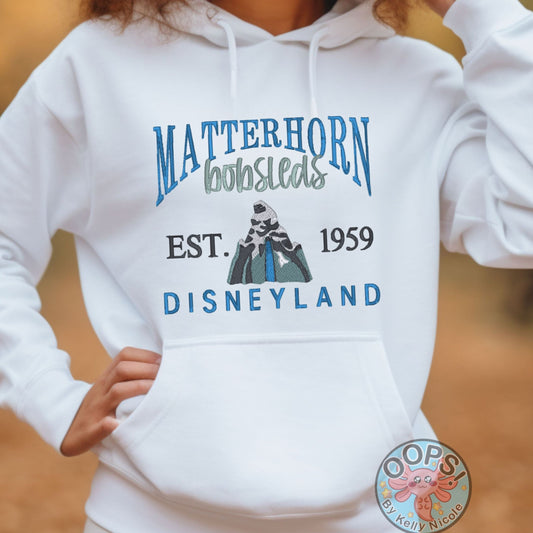 DISNEY “MATTERHORN” Theme Park Embroidered Heavyweight Unisex Hoodie in WHITE. Shop online today to get yours at HTTPS://OOPSBYKELLYNICOLE.COM