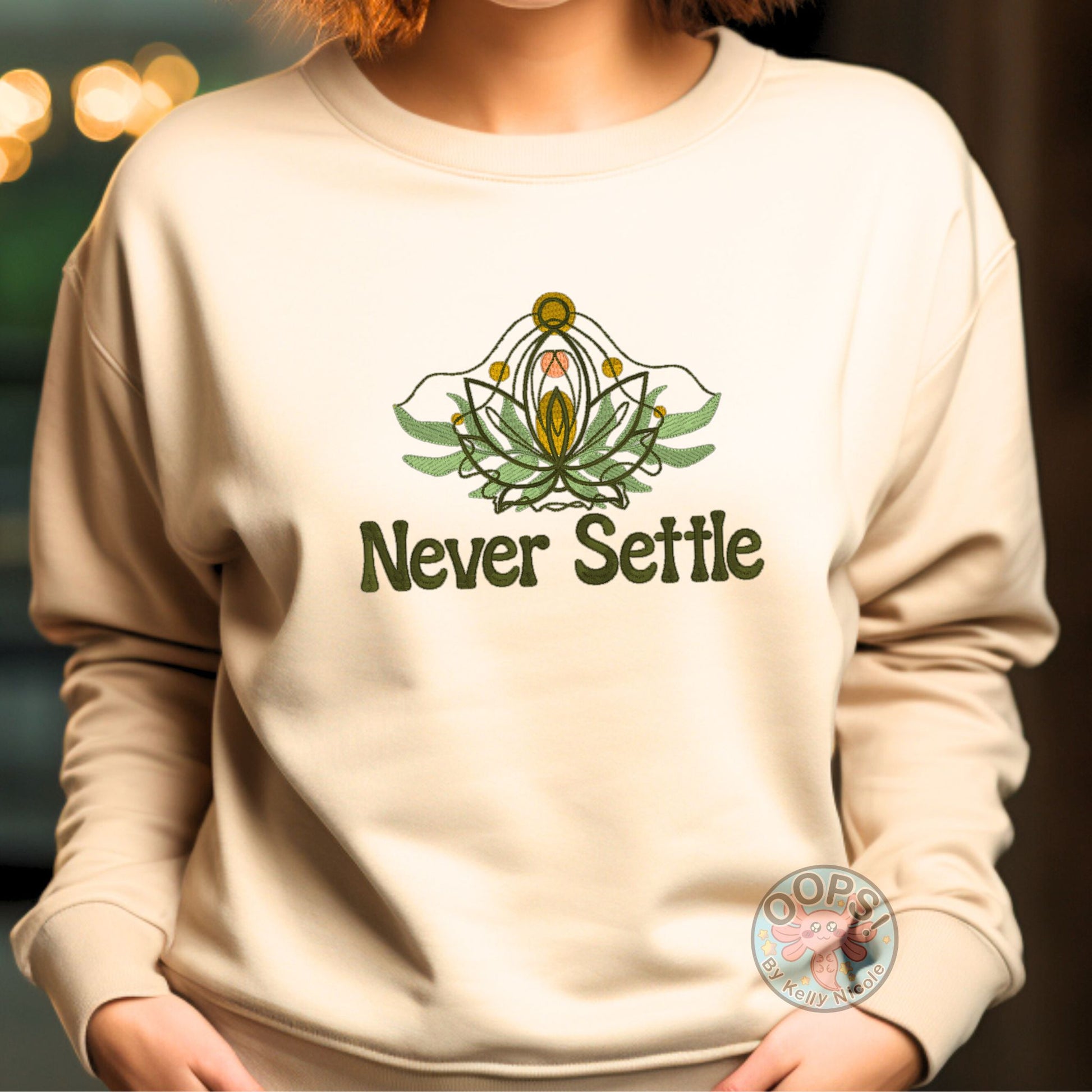 Embroidered “Never Settle” Sand Unisex Sweatshirt perfect for Home, work or anytime cozy comfort wear.  Order yours today at https://oopsbykellynicole.com.