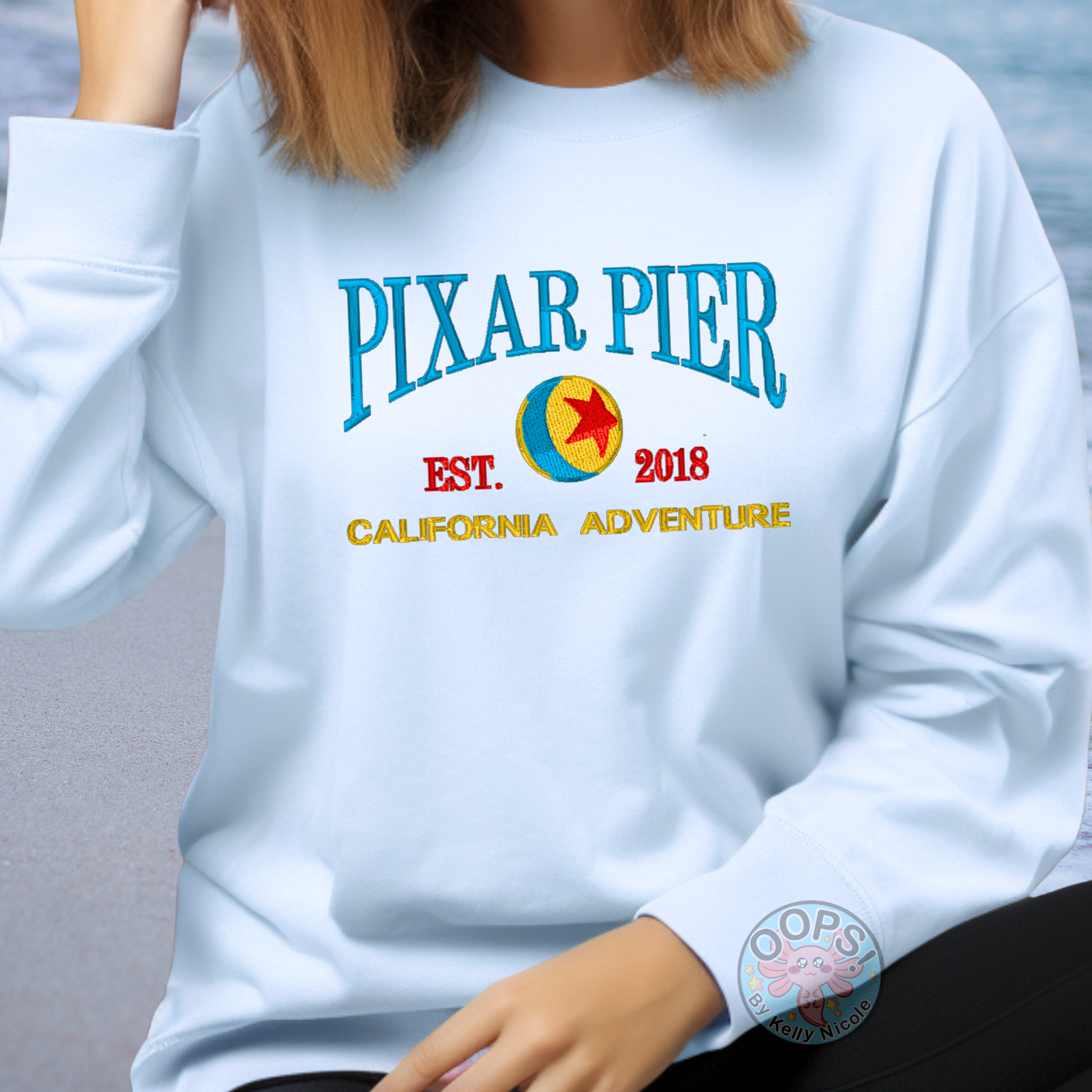 Embroidered Disney “Pixar Pier” DCA inspired  Unisex  Sweatshirt in Blue. Perfect for Home, work or anytime cozy comfort wear.  Order yours today at https://oopsbykellynicole.com.