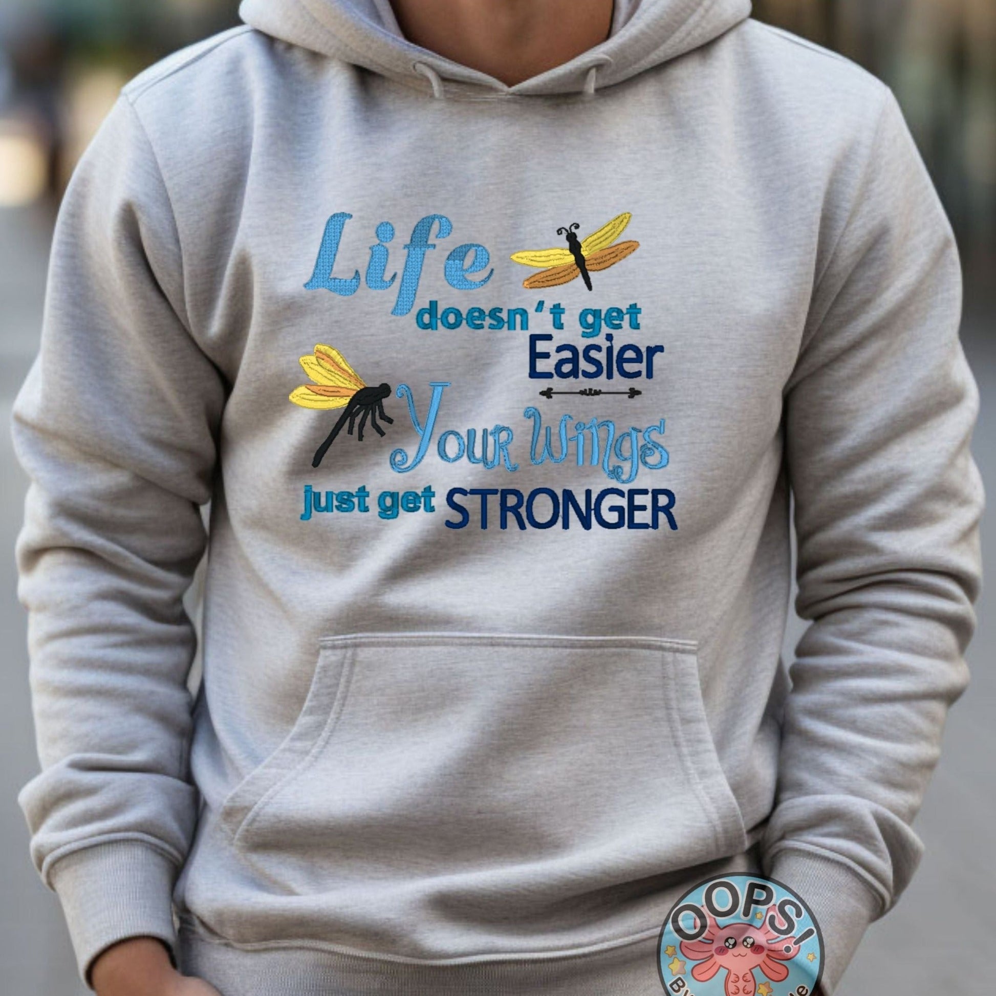  "LIFE DOESN'T GET EASIER, YOUR WINGS GET STRONGER". Inspirational Inspirational Embroidered Heavyweight Unisex Hoodie in ASH.  Shop online today to get yours at HTTPS://OOPSBYKELLYNICOLE.COM 